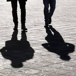 Twee personen en hun schaduwen op straat