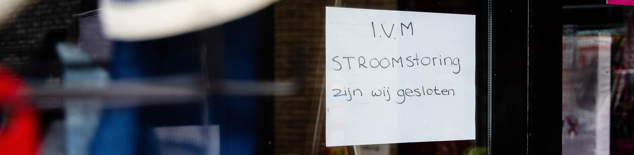 Winkeldeur met een briefje waarop staat dat de winkel gesloten is in verband met een stroomstoring