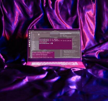 Laptop met cryptische tekst tegen achtergrond van paarse geplooide stof